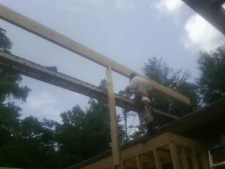 Carpenter setting a ridge beam over a new addition frame — Ice Dam Removal by Roofing Brothers in Lake Station