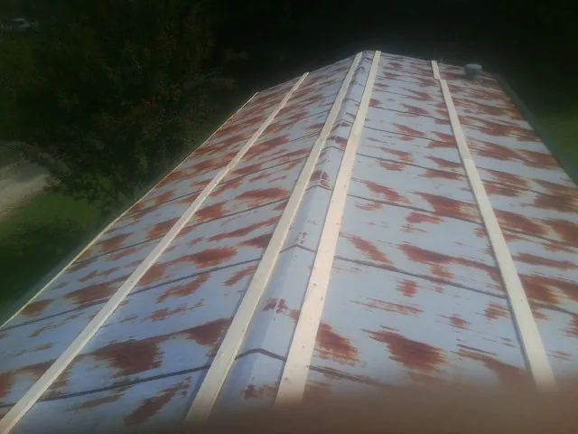 Rusted metal roof panels with new wood purlins before replacement — Storm Damage Roof Repair in Lake Station by Roofing Brothers