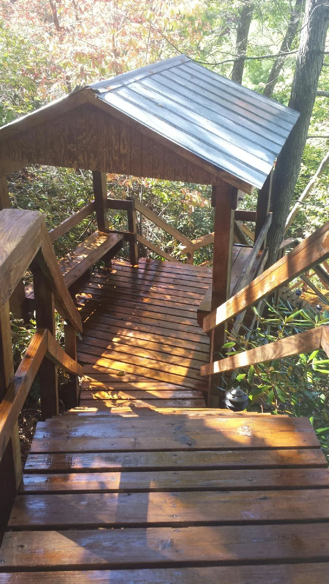 Freshly stained wood walkway and covered shelter with a metal roof in Lake Station