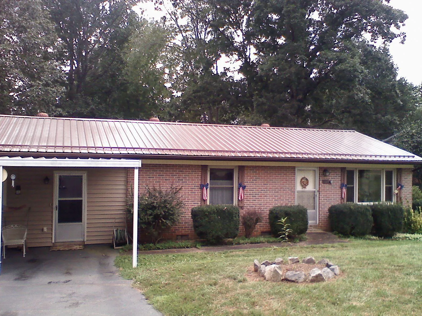 Bronze metal roof and carport on a brick ranch home — Roof Repair work by our crew in Lake Station