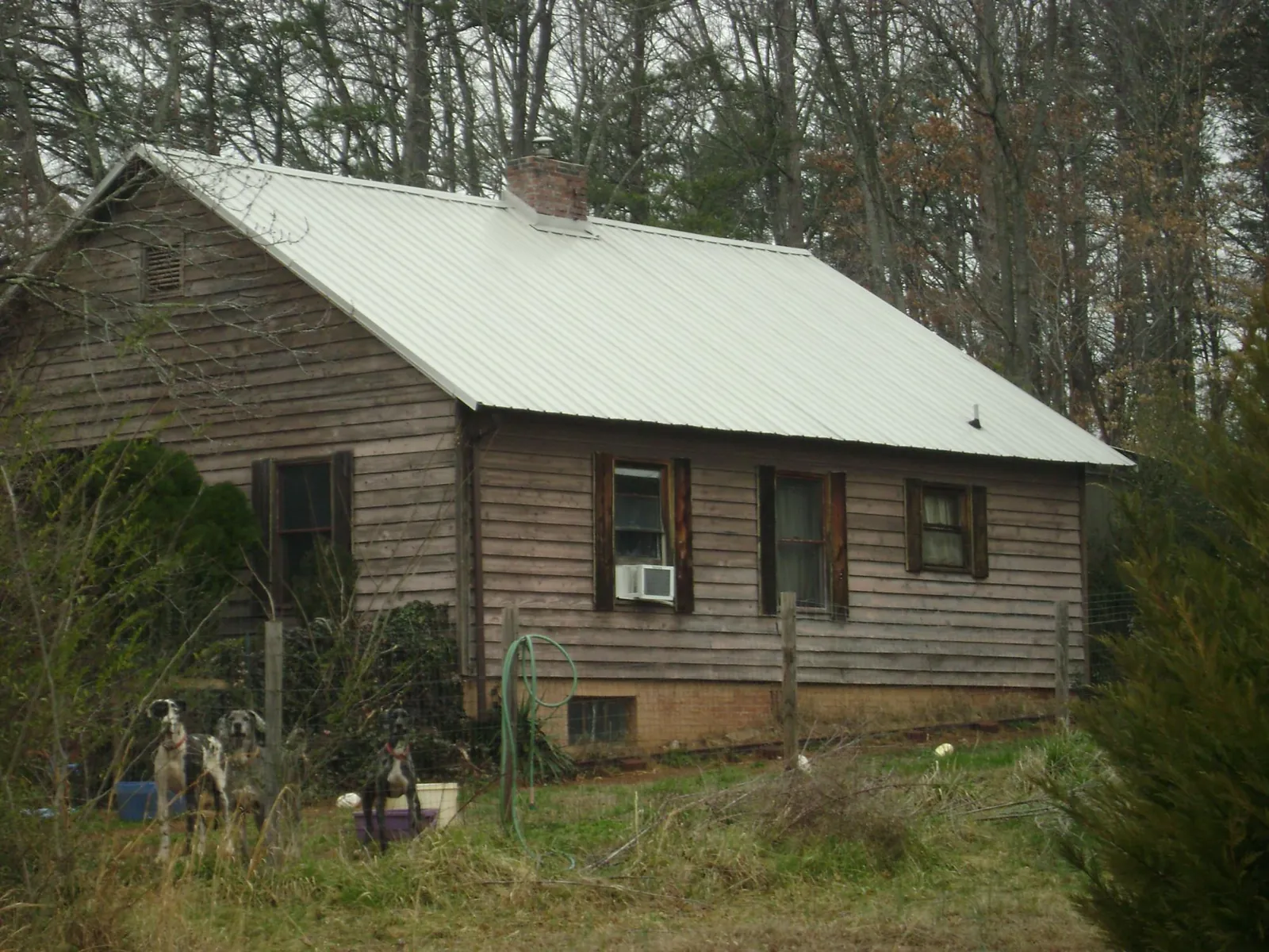 White metal roof on an old wood sided farmhouse, from a Metal Roof Installation job in Lake Station